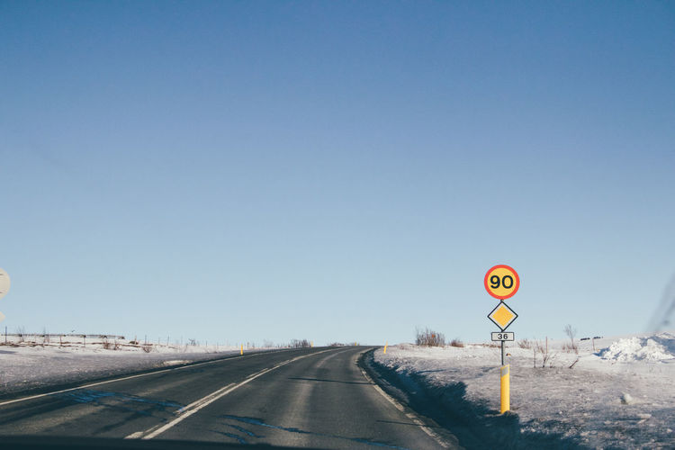 Road sign against clear sky