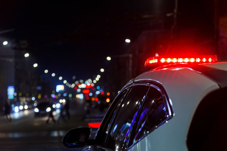 Police car lights in night city with selective focus and bokeh