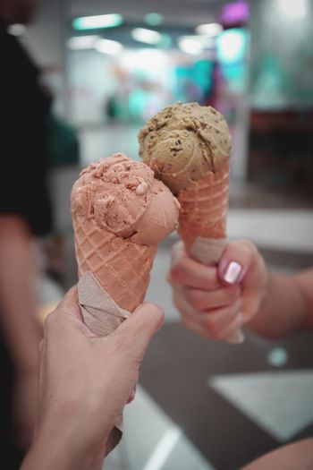 Cropped hands holding ice cream cones
