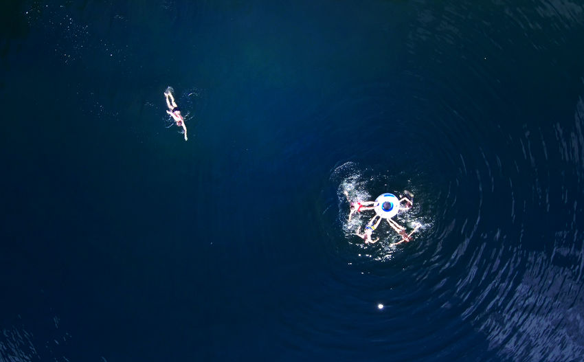 High angle view of people swimming on sea