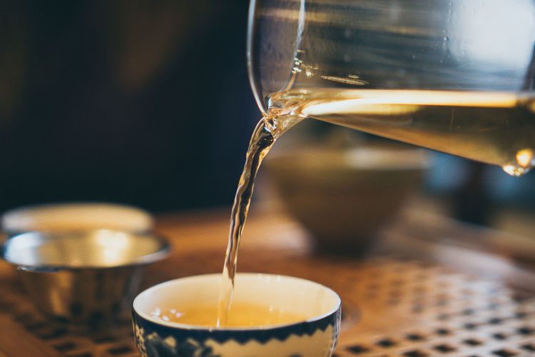 Close-up of tea being poured in cup