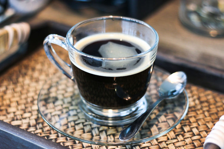 Close-up of cup of black coffee served in glass cup