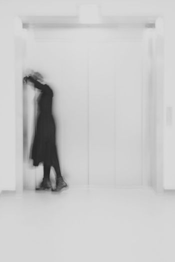 Side view of woman walking against wall in building