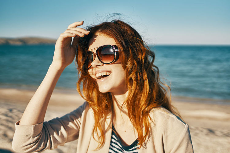 Portrait of young woman wearing sunglasses on beach