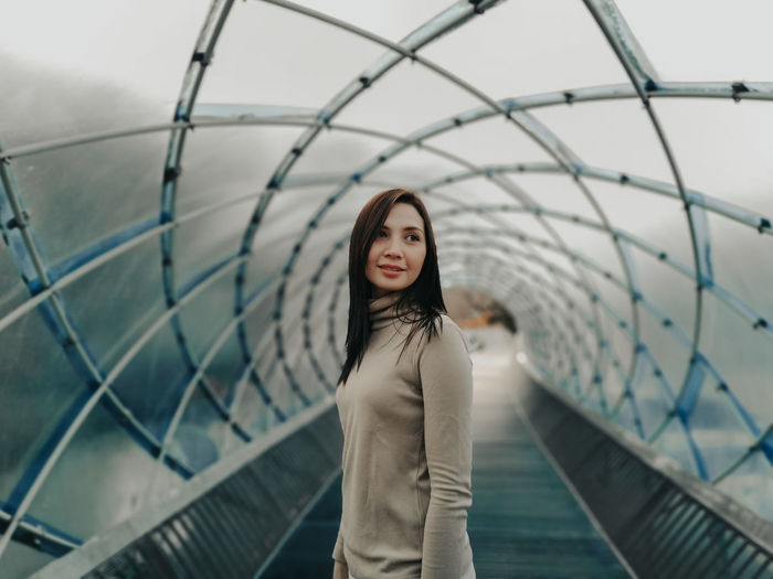 Woman standing under covered bridge