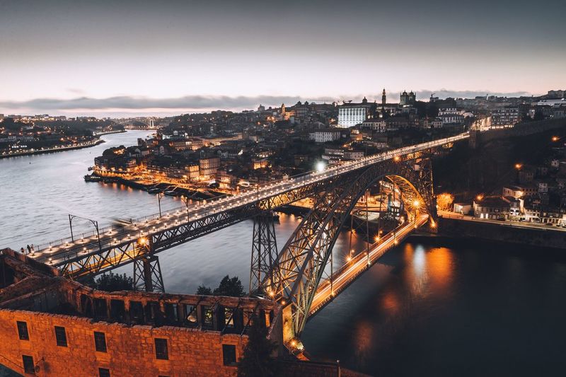 High angle view of bridge over river in city at dusk