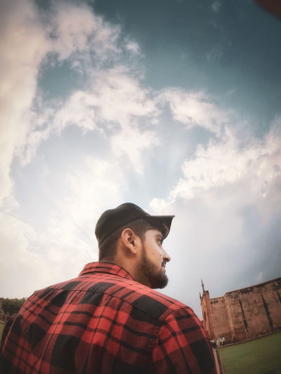 Low angle view of man looking away against sky