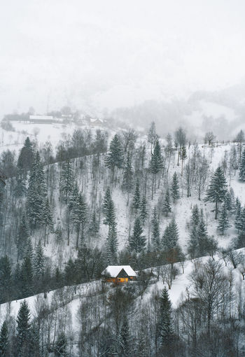 View of a barn on snowy hill in a foggy winter day