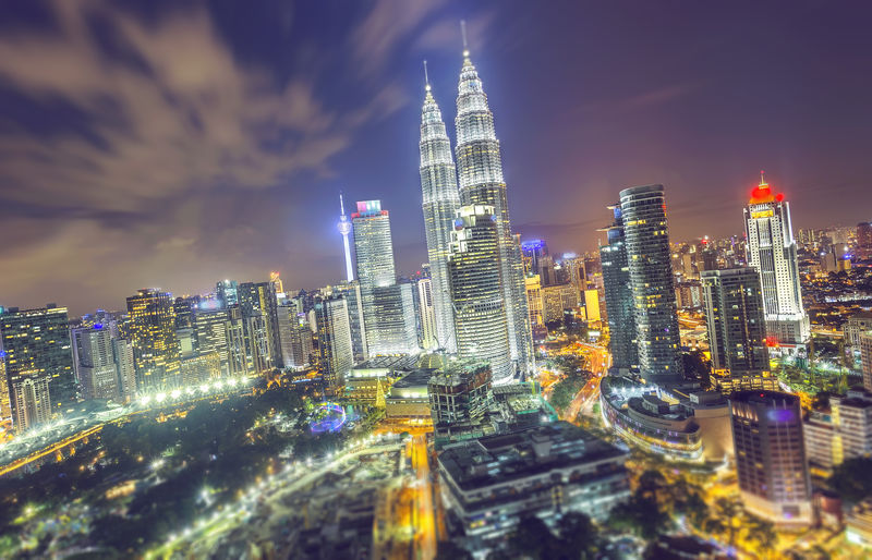 Illuminated city against sky at night