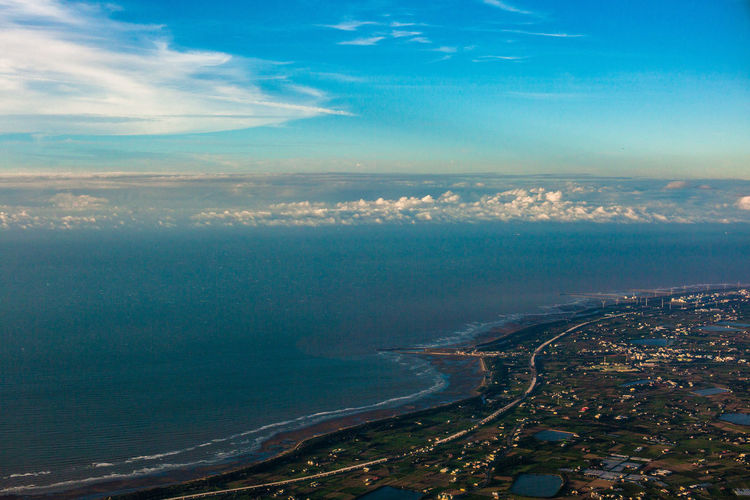 Aerial view of sea and city against sky