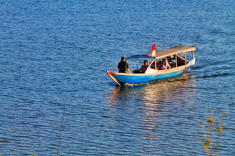 People in boat sailing in sea