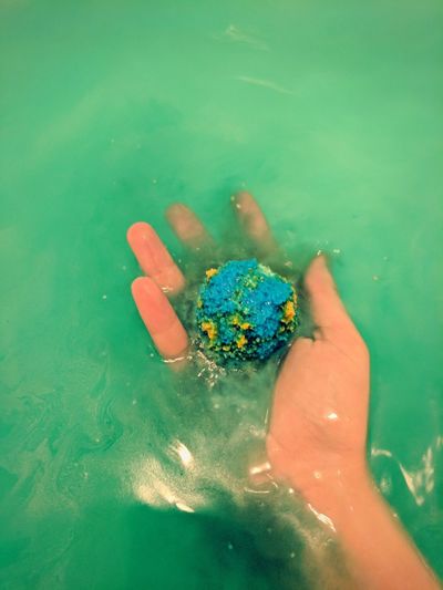 High angle view of woman holding sponge in water