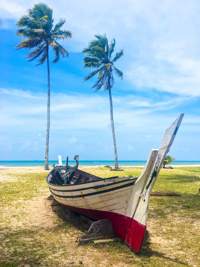 Ship moored on beach against sky