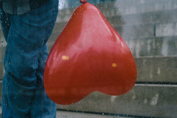 Close-up of wet person holding umbrella during rainy season