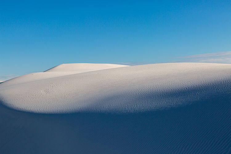 Pristine sand dunes with a blue sky overhead, at white sands national park in new mexico