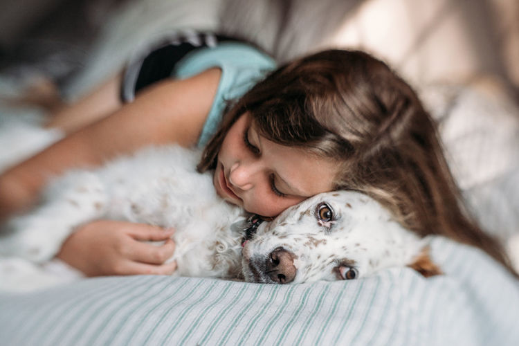 Portrait of young woman hugging her dog