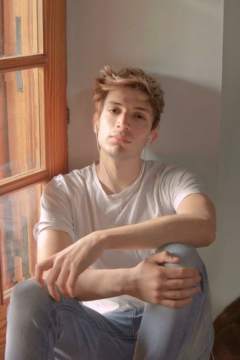Young man looking away while sitting at home