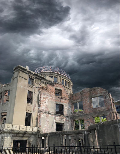 Low angle view of old building against cloudy sky
