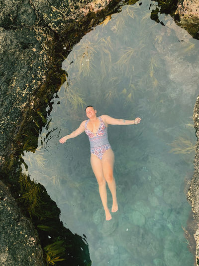 High angle view of woman floating on tidal pool