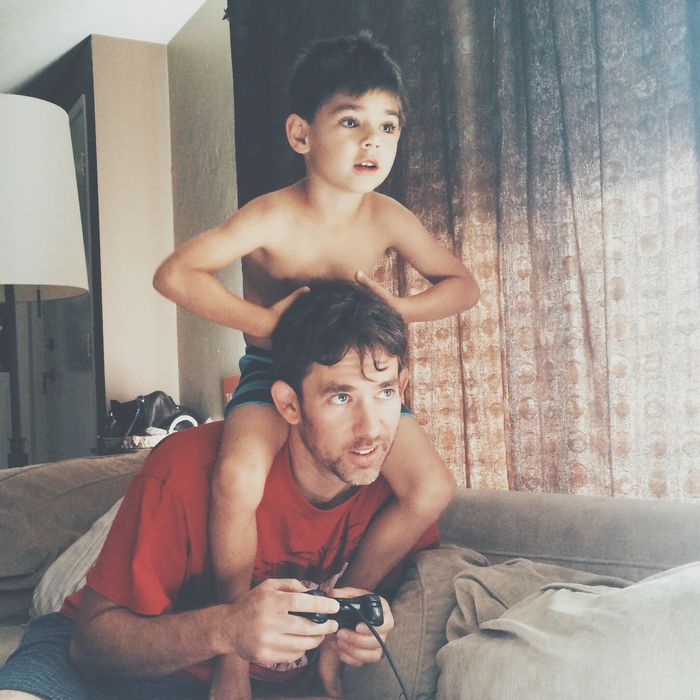 Father and son playing video game at home