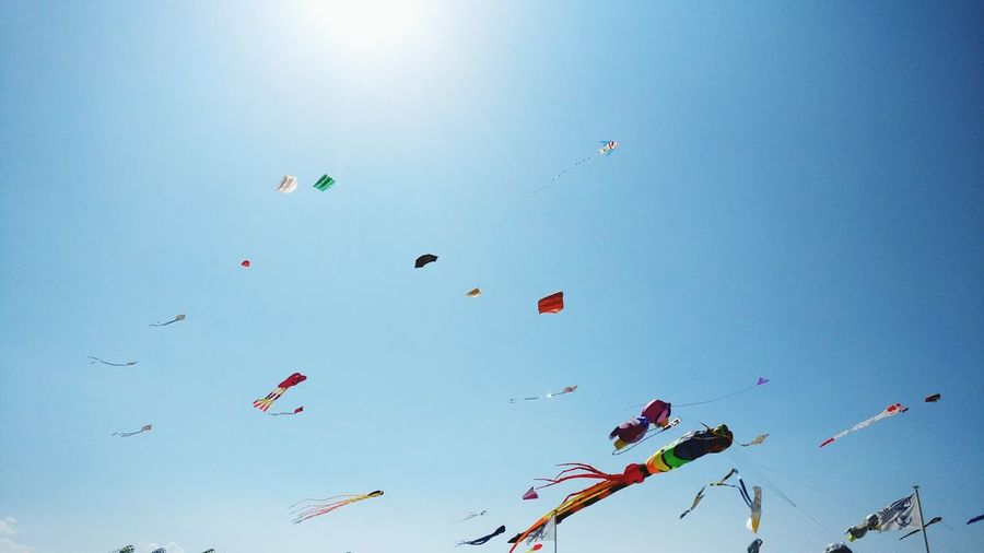 Low angle view of kites against clear sky