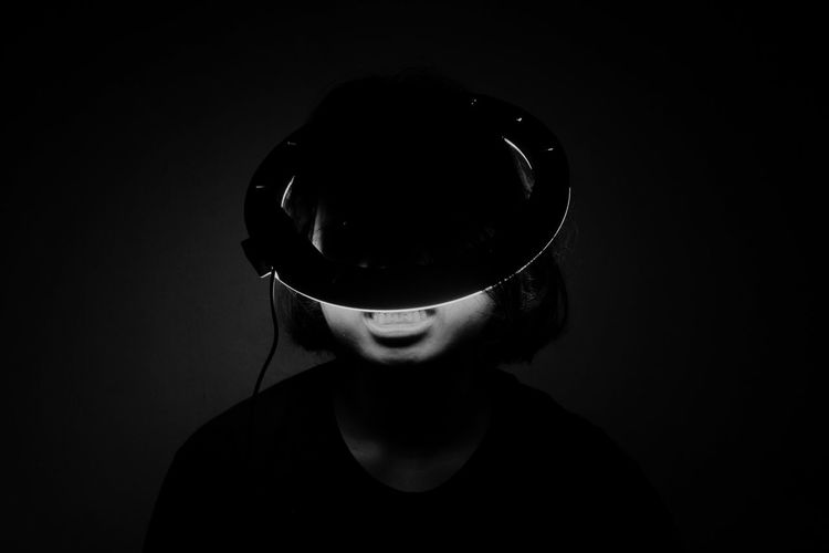 Young man wearing sunglasses against black background