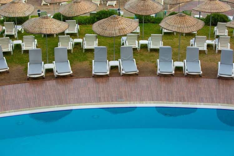 High angle view of lounge chairs at swimming pool