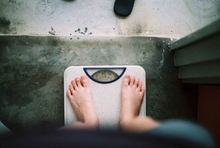 Low section of person standing on weight scale