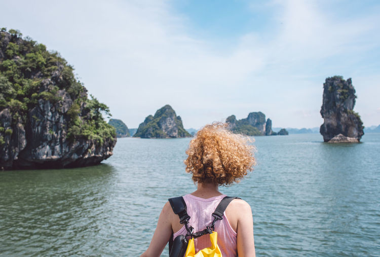 Rear view of woman looking at sea against sky