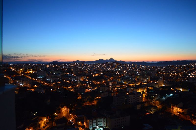 Illuminated cityscape against clear sky at night