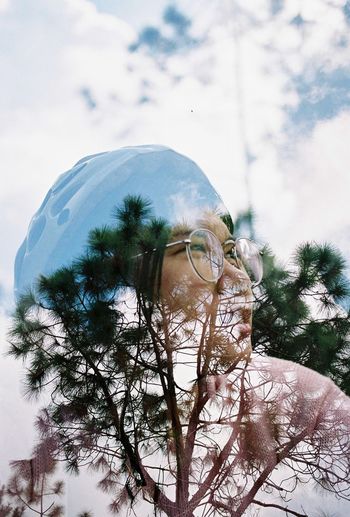 Digital composite image of man and tree against sky