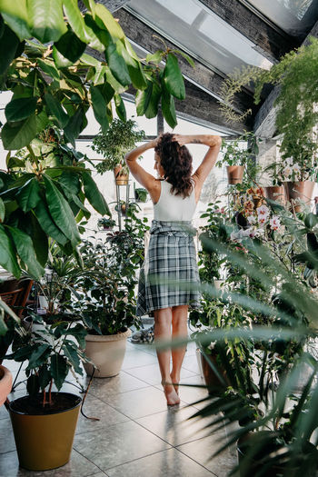 Rear view of woman standing by plants