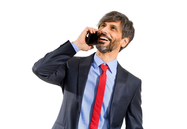 Mid adult man using smart phone against white background
