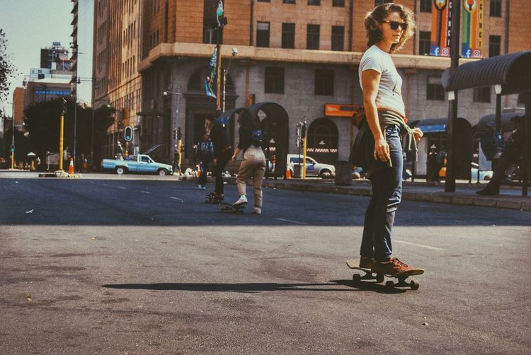 Woman skateboarding on street in city