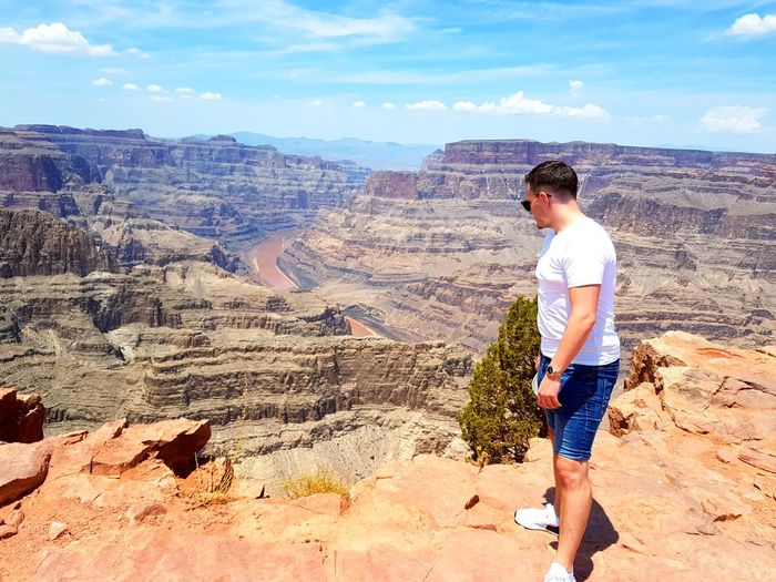 Side view of man standing at grand canyon national park against sky