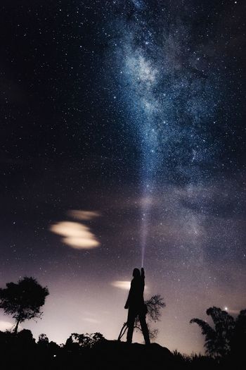 Person lighting sky with flashlight