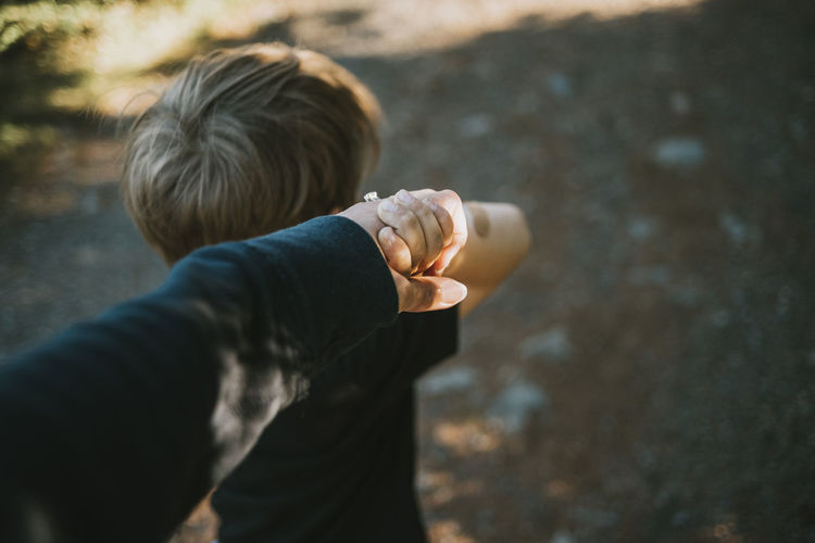 Cropped images of mother holding hands of son