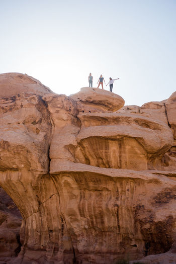 Three hikers explore a scenic canyon in the desert