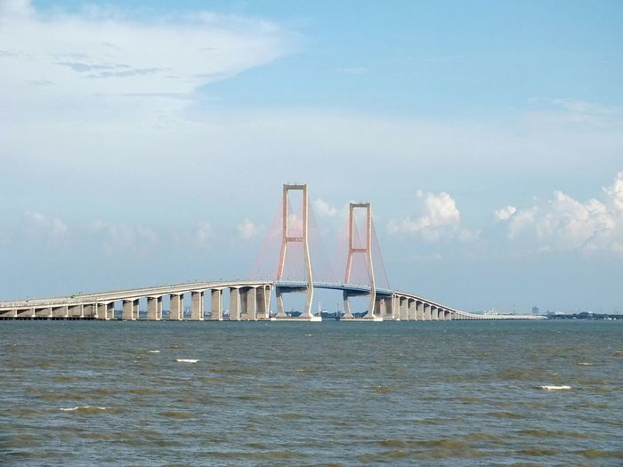 Built structure by river against sky