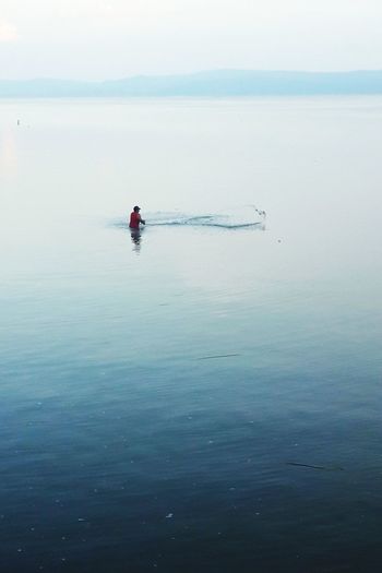 Man in sea against sky