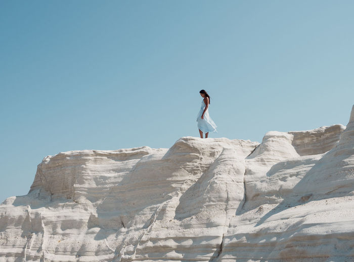 Full length of man standing on rock against sky