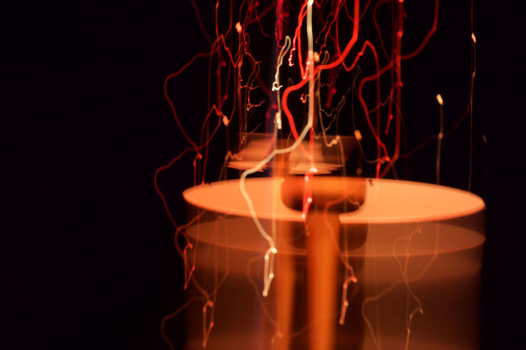 Blurred motion of tea light candles burning in darkroom