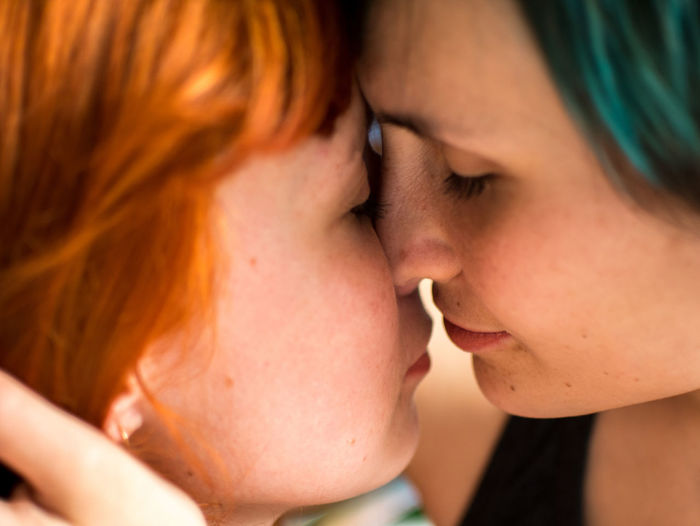 Close-up of lesbian couple kissing at home