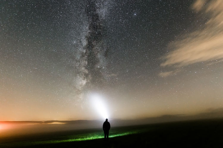 Person standing against star field at night