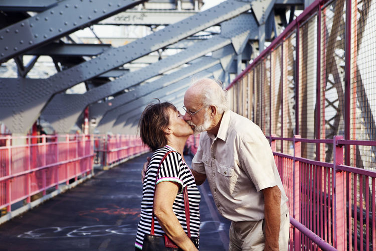 Senior couple kissing on bridge