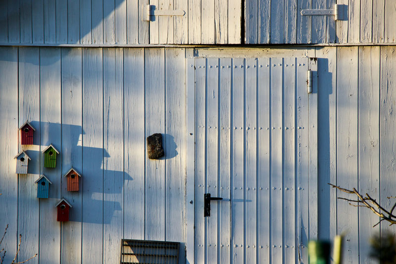 Full frame shot of white wooden wall with bird houses