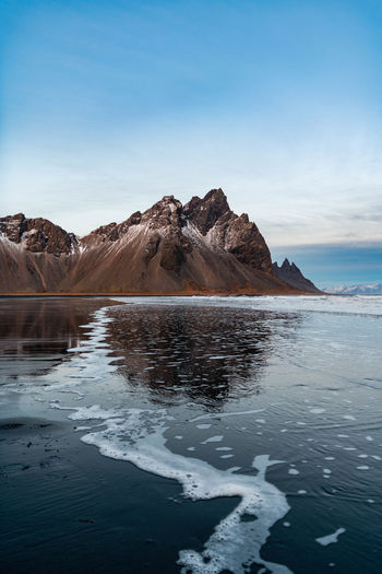 View of vestrahorn against the black sand beach in iceland