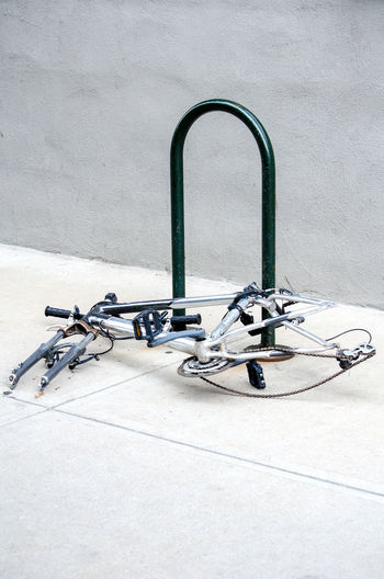 High angle view of bicycle on cement with parts stolen and bare frame locked up
