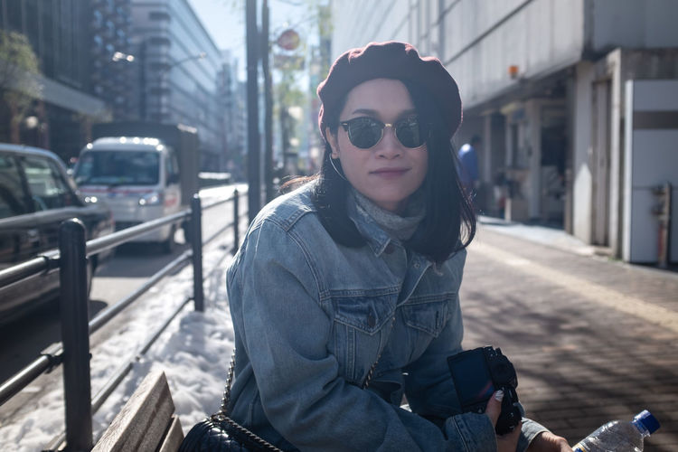 Portrait of woman wearing sunglasses in city