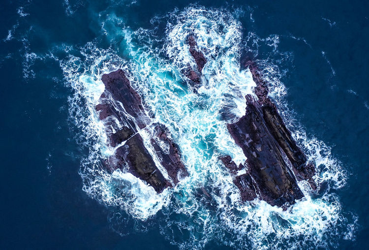 Aerial view of ocean against cliffs